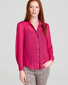 A contrast faux leather trim lends a sophisticated finish to this boldly hued blouse from Alice + Olivia.