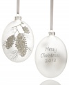 Serene and understated, this frosted glass ornament turns your home into a winter wonderland. Silver pine cones and a message of seasonal cheer glisten in silver glitter. Shown front and back.