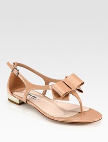 Patent leather t-strap sandal with bow adornment and adjustable ankle strap. Patent leather upperLeather lining and solePadded insoleMade in ItalyOUR FIT MODEL RECOMMENDS ordering true size. 