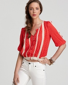 As pretty as an English rose, this Free People red, dot print top is the refreshes your wardrobe with a youthful spirit and lighthearted sensibility. Top off your crispest white pants with the vibrant piece and sparkle!