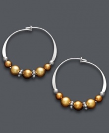 A tri-color blend spices up a traditional pair of hoop earrings. Jody Coyote's unique design offers a metallic mix of copper and gold Austrian crystal pearls threaded onto delicate, sterling silver hoops. Approximate diameter: 3/4 inch.