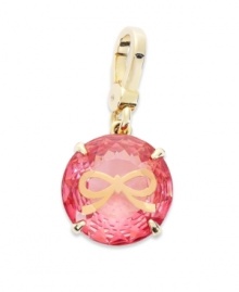 Juicy Couture's pretty charm features a round-cut solitaire pink epoxy stone engraved with a small bow. Set in a four prong gold tone brass setting. Lobster clasp closure. Approximate drop: 1-1/2 inches.