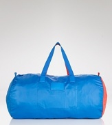 Not your basic weekender: trend-right cobalt and red accents embolden this MARC BY MARC JACOBS duffel bag that packs away for a convenient (and colorful) statement.