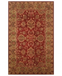 Drawing inspiration from the sandy ruins of ancient Petra and the traditional designs of India, this elegant, hand-tufted rug presents a rich decorative history set against a subtle red backdrop and accented with multiple gold and green tones.