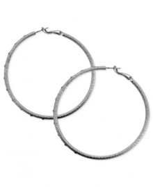 A stylish must-have. These clutchless hoop earrings from GUESS feature a diamond dust design with glass stones. Crafted in silver tone mixed metal. Approximate diameter: 2-1/2 inches.