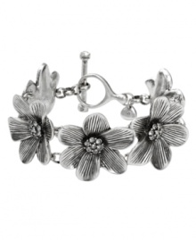 Let your style bloom this season! Fossil's station bracelet boasts sculpted flowers accented by clear crystal accents. Crafted in silver tone mixed metal. A toggle closure holds everything together. Approximate length: 8 inches.