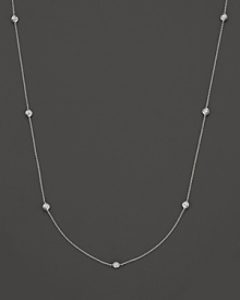 A white gold necklace with seven bezel-set diamond stations; with signature ruby accent. Designed by Roberto Coin.